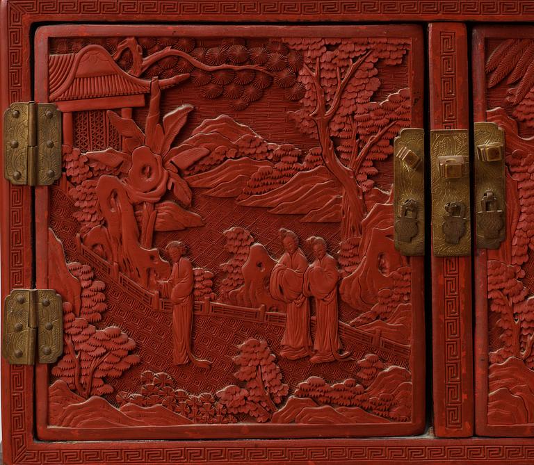 A well carved Cinnaber lacquer 'Kang'Cabinet, Qing dynasty, 18/19th Century.