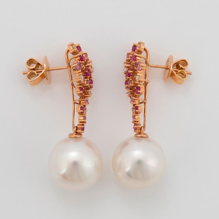 Ett par örhängen med odlade Söderhavspärlor samt runda briljantslipade diamanter och rosa safirer.