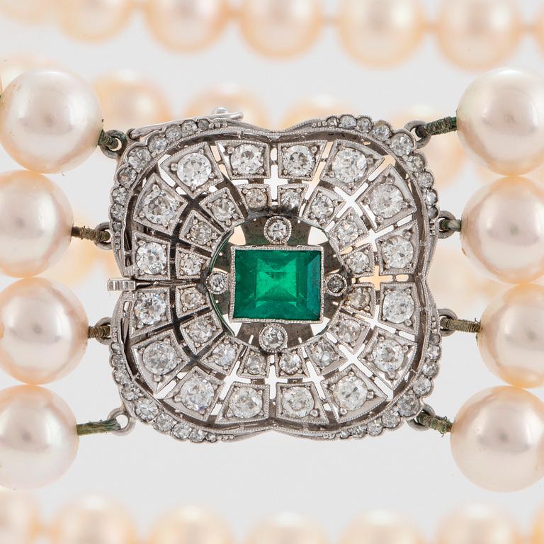 A four strand cultured pearl necklace with an 18K white gold clasp set with a faceted emerald.