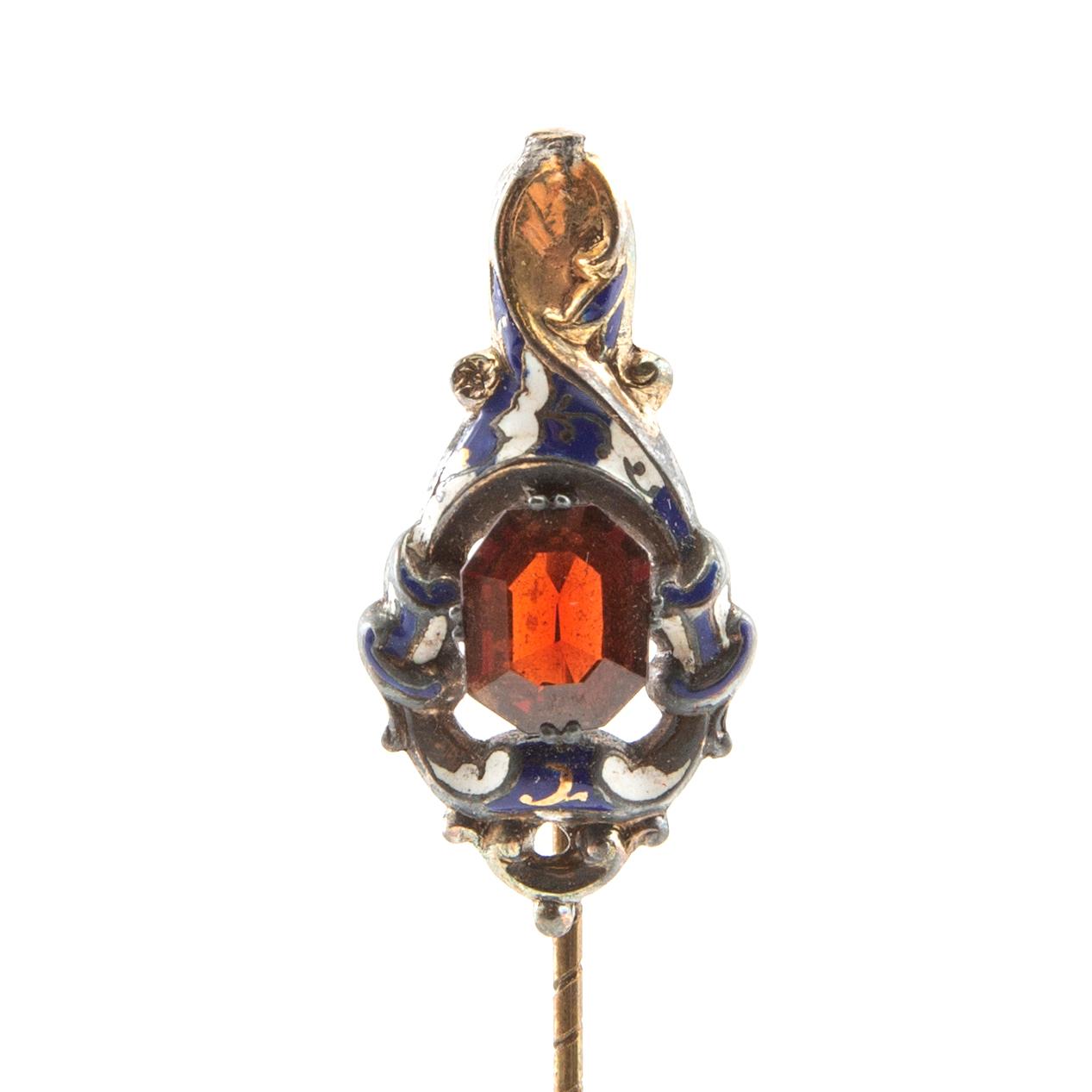Tie pin of gilded brass with decoration of enamel and a faceted garnet, second half of the 19th century.