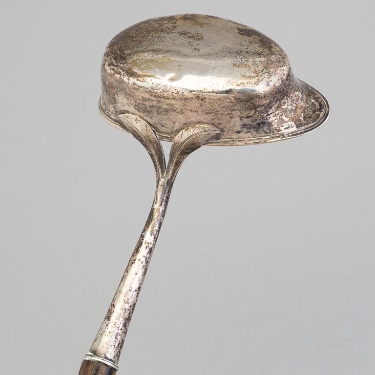 A 19th century silver soup and a sauce ladle with wooden handles.