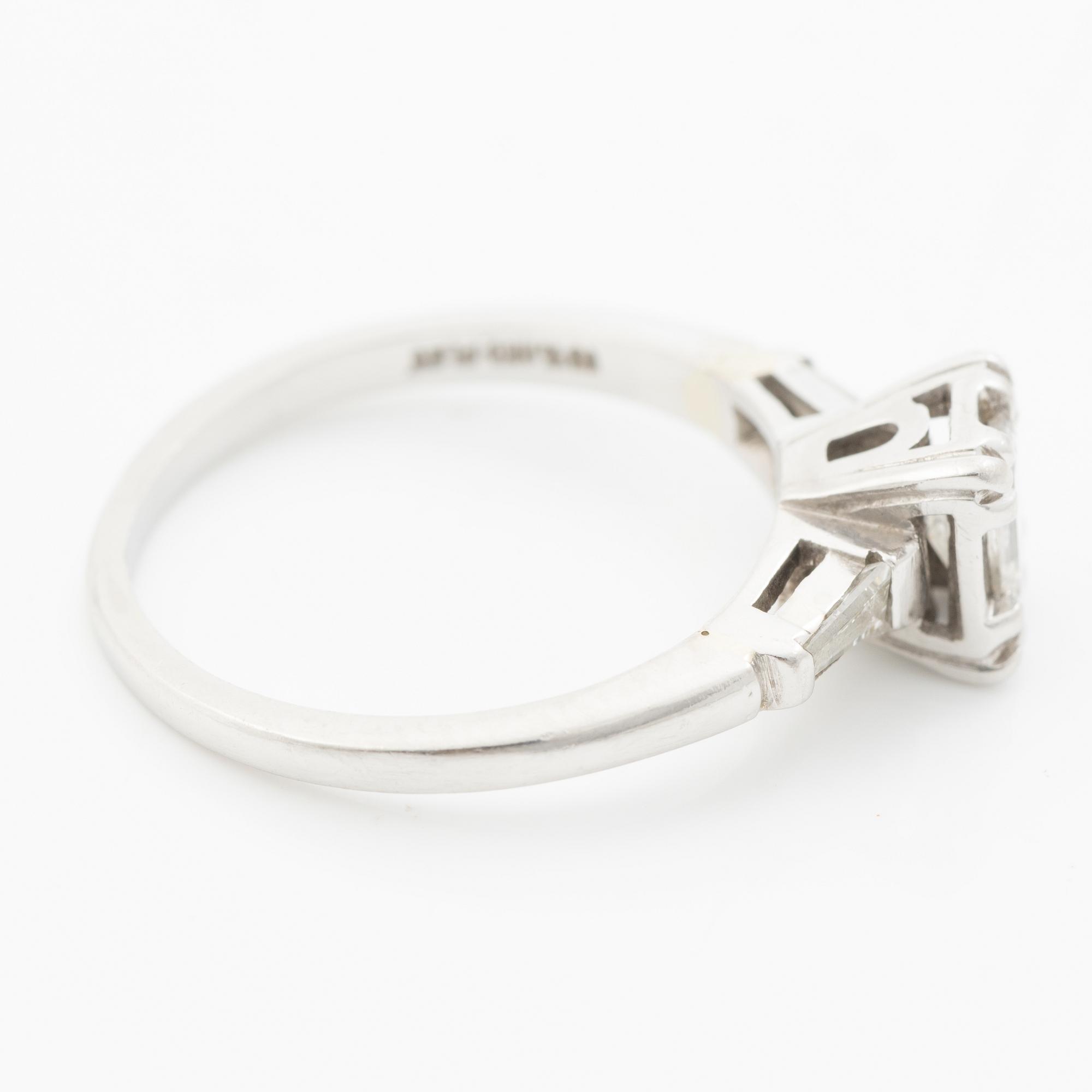 Platinum ring with an emerald-cut diamond and modified baguette-cut diamonds.