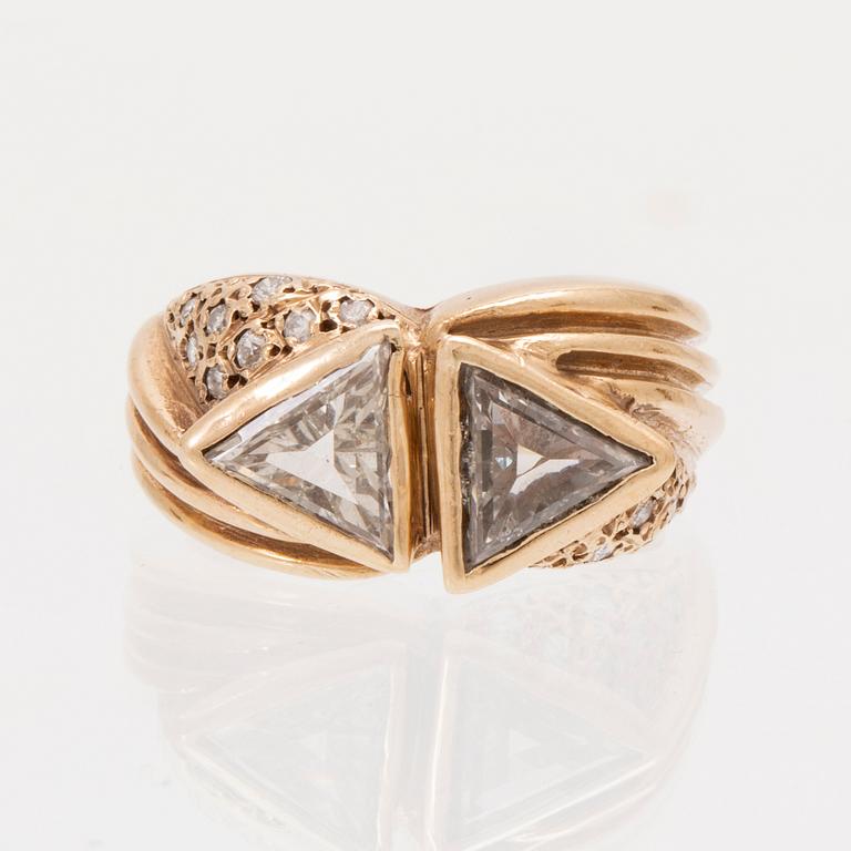 A 14K gold ring set with trillion and round brilliant cut diamonds.