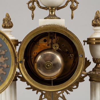 A Louis XVI style pendulum clock and a pair of candelabra, early 20th century.