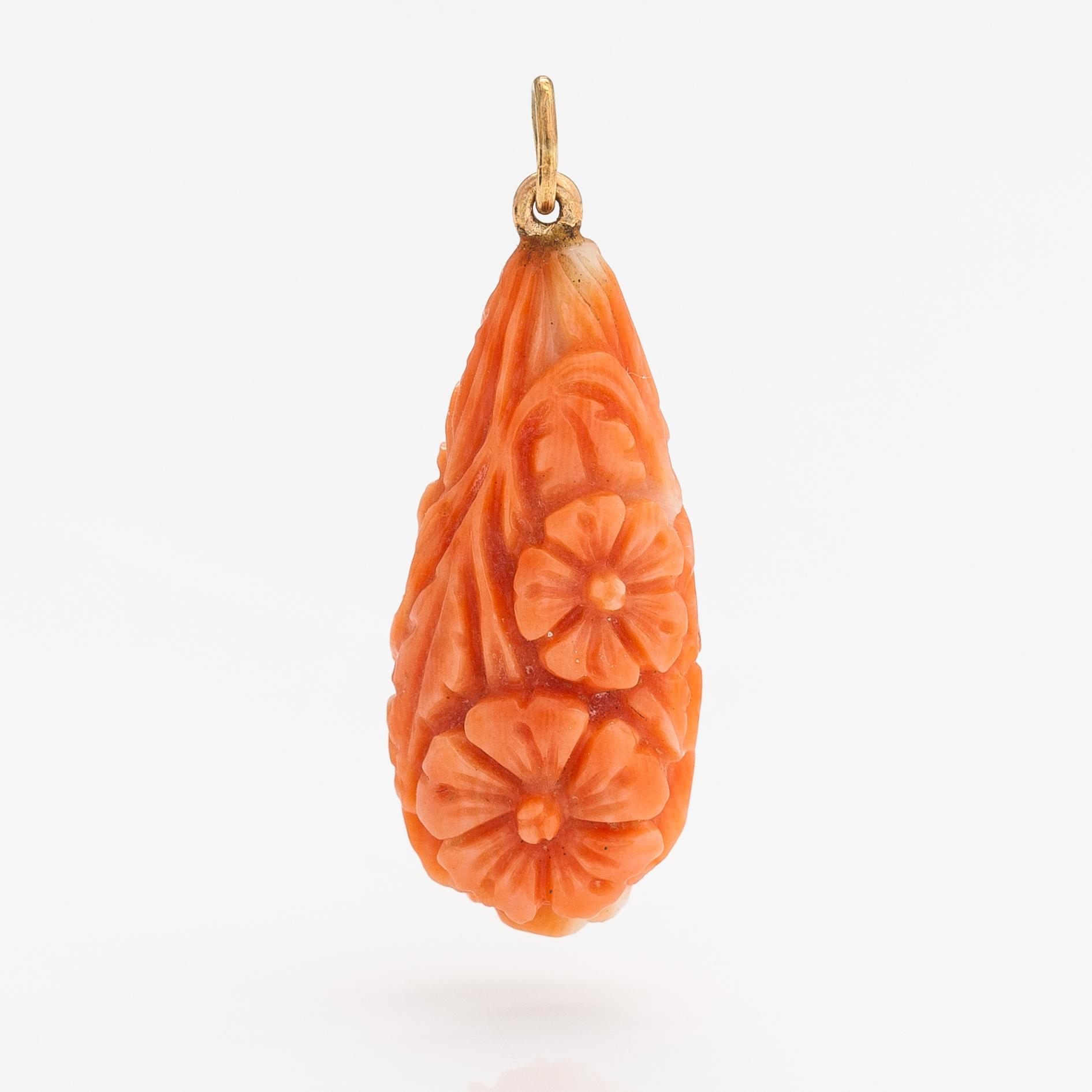 A pendant with carved coral and gold.
