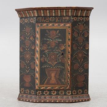 A corner hanging cabinet, dated 1844.