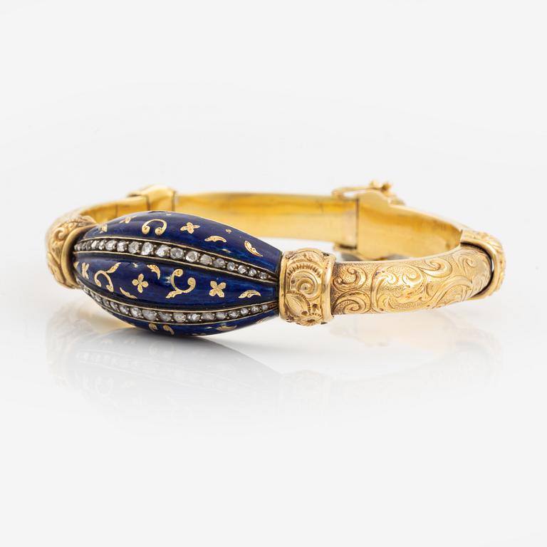 Armring, guld, blå emalj och rosenstenar.