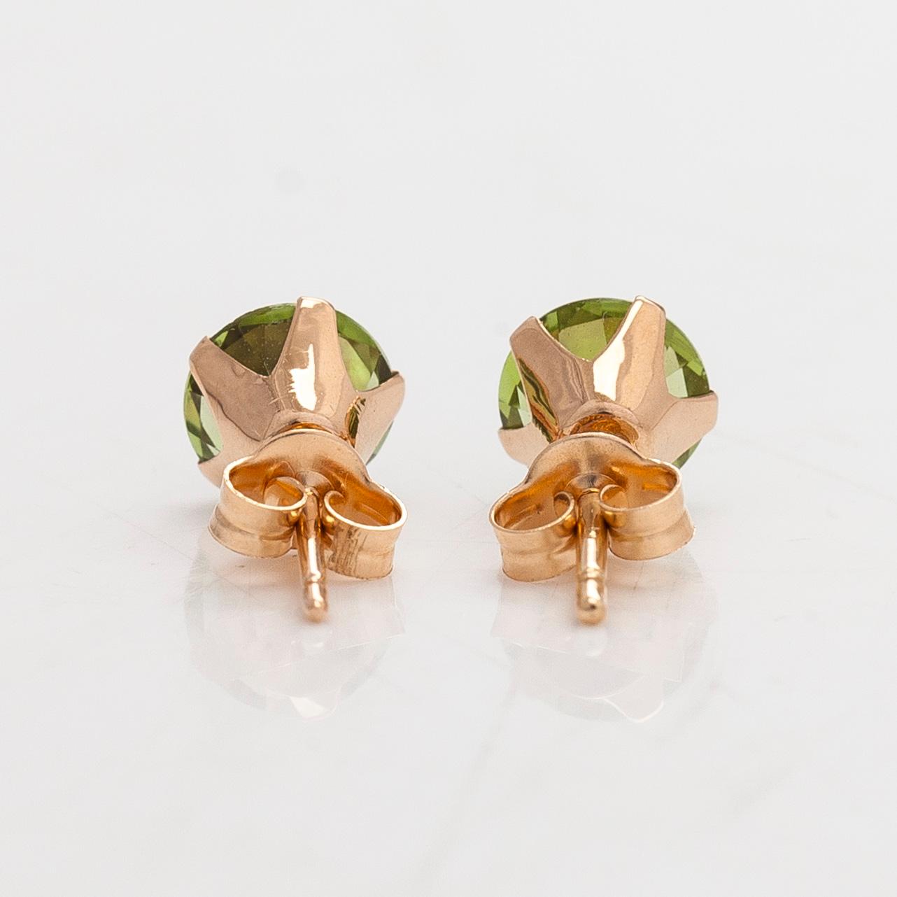 A pair of earrings, approx 12/14K gold with peridots.