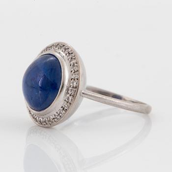 An A Tillander ring in 18K white gold set with a cabochon-cut sapphire and eight-cut diamonds.