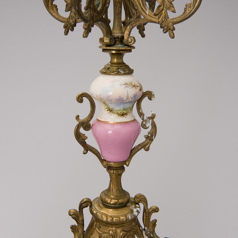 A pair of gilt-bronze Rococo Revival candelabra with porcelain decors, from the latter half of the 19th century.