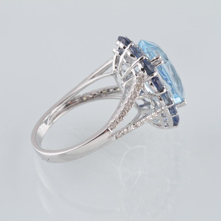 RING, 18K vitguld med briljantslipade diamanter ca 0.24 ct, blå safirer ca 2.05 ct samt topas ca 6.93 ct. Vikt 5,6 g.