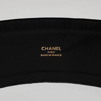 CHANEL, a black fabric and leather belt with gold colored buckle.