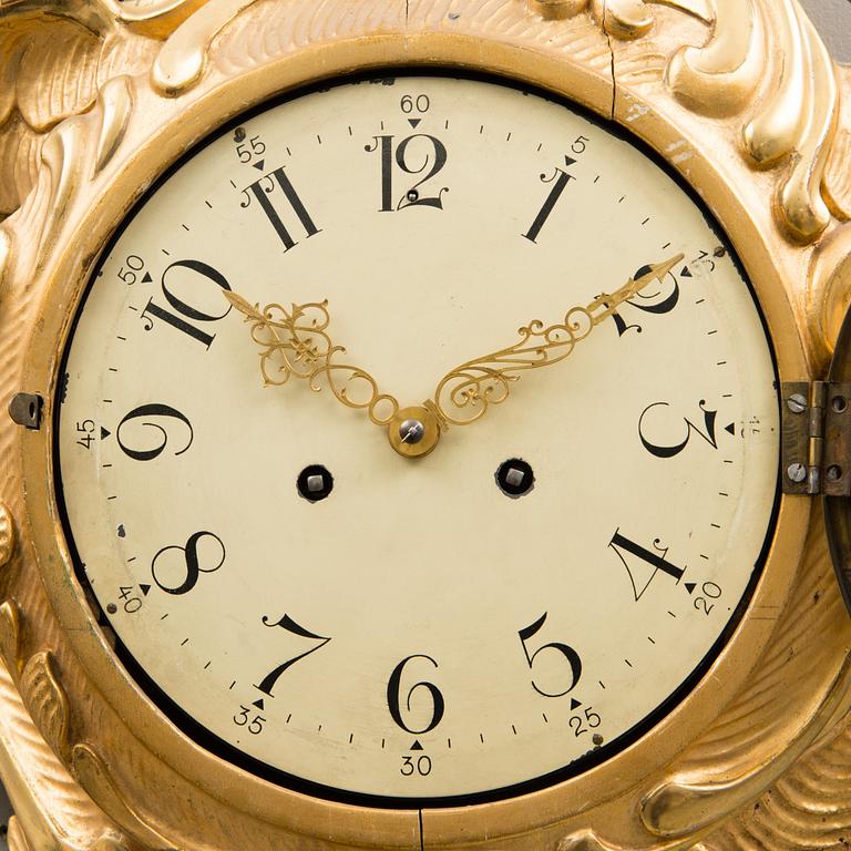 A Rococo-style pendulum wall clock from the 20th century.