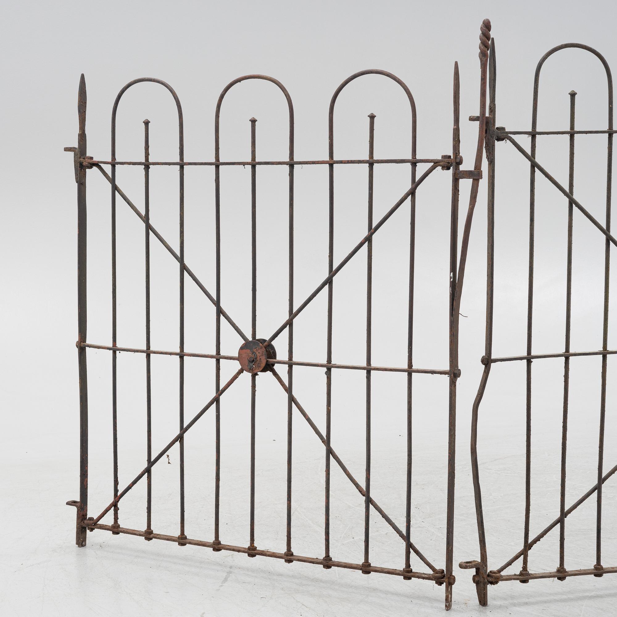 A pair of iron garden gates and a single gate from the early 20th century.