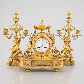 A Louis XVI style mantel clock and a pair of candelabra, France, second half of the 19th century.