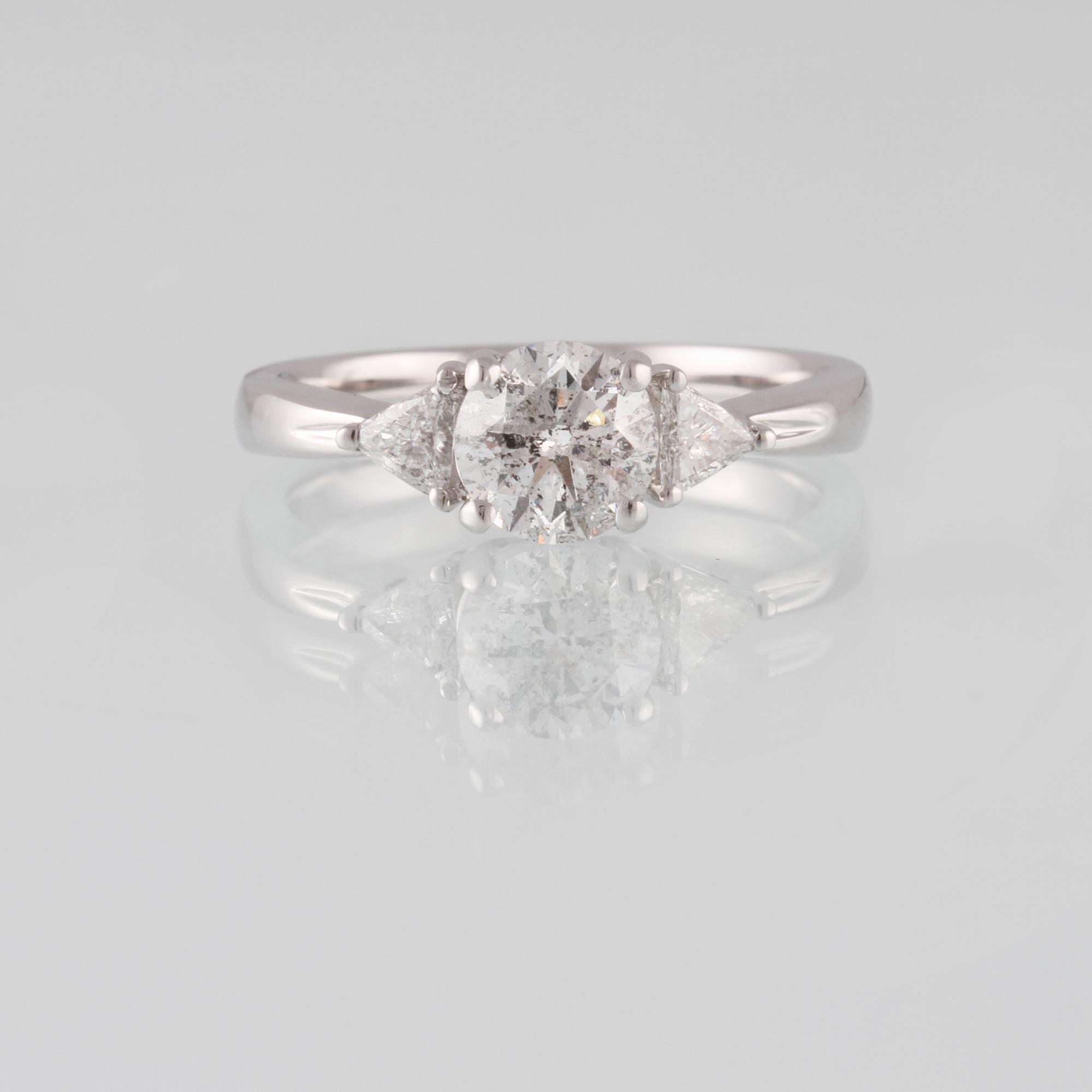 RING, 18K vitguld med briljantslipad diamant 1.03 ct samt 2 triangelslipade diamanter 0.17 ct. Vikt 4,4 gram.