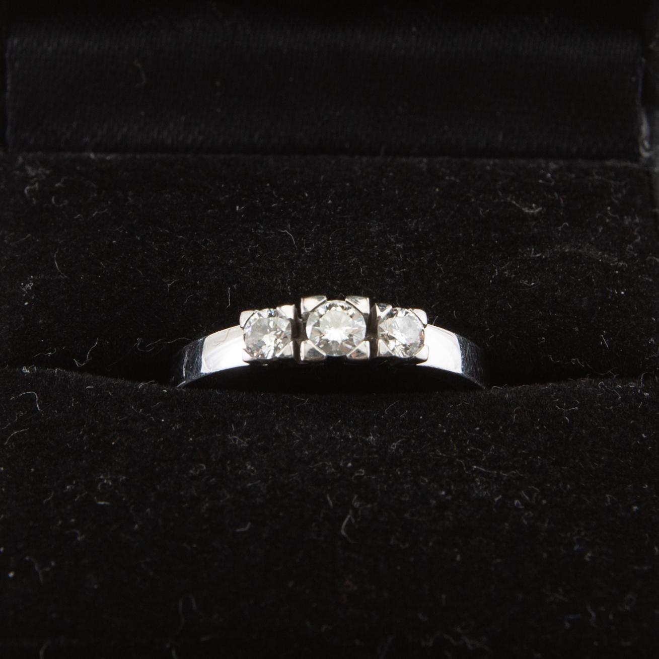 Ring, 18K vitguld med tre runda briljantslipade diamanter.