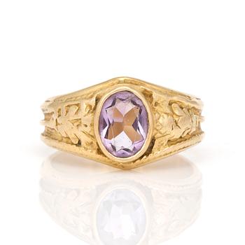 A ring with oval, mixed-cut amethyst.