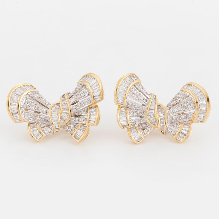 A pair of earrings in the shape of bows set with round, brilliant and tapered, baguette-cut diamonds.