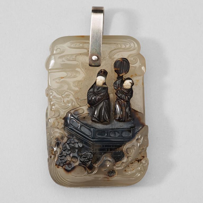 A carved dendric quarts pendant with figures on a terrace, and characters on the reverse, Qing dynasty, 19th Century.