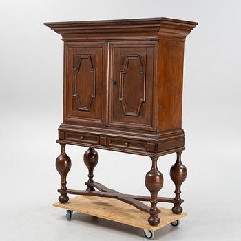 A stained pine Baroque cabinet, on a later stand. From around the year 1700.