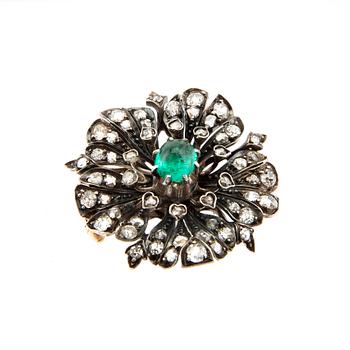 A 14K gold brooch set with a cabochon-cut emerald and old-cut as well as rose-cut diamonds.