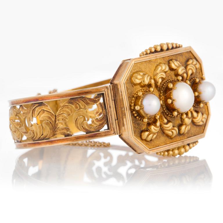 An 18K gold bracelet set with three pearls.