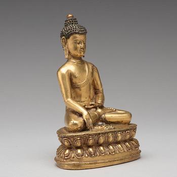 A gilt copper alloy figure of Akshobhya, Tibet, 16th Century.