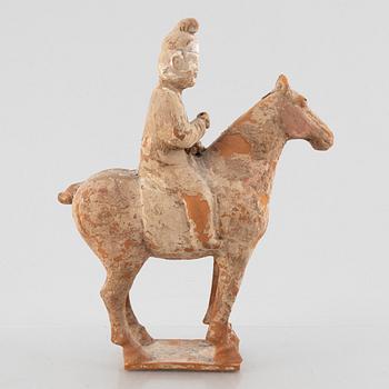 A painted pottery figure of an equestrian standard-bearer, Tang dynasty (618-907 AD.).