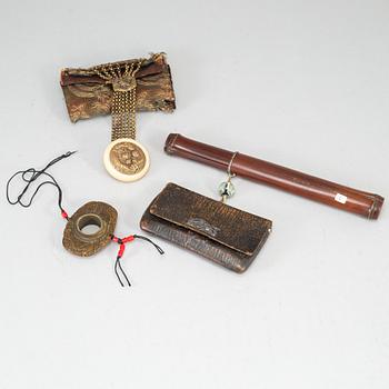 Two Japanese tobacco pouches, one with a pipecase and pipe, Meiji period (1868-1912), and a carved ornament.