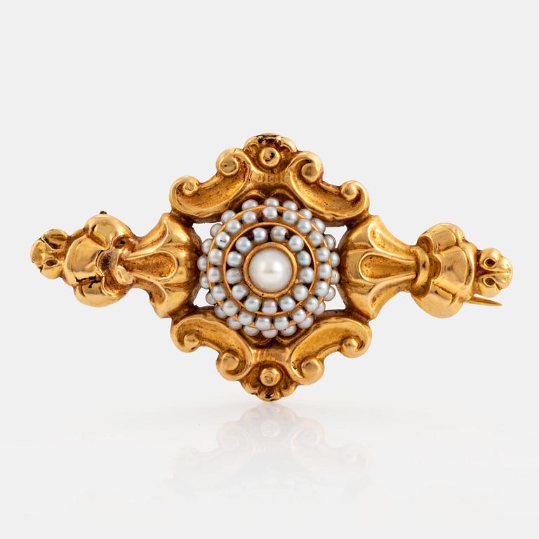 An 18K gold brooch set with pearls.