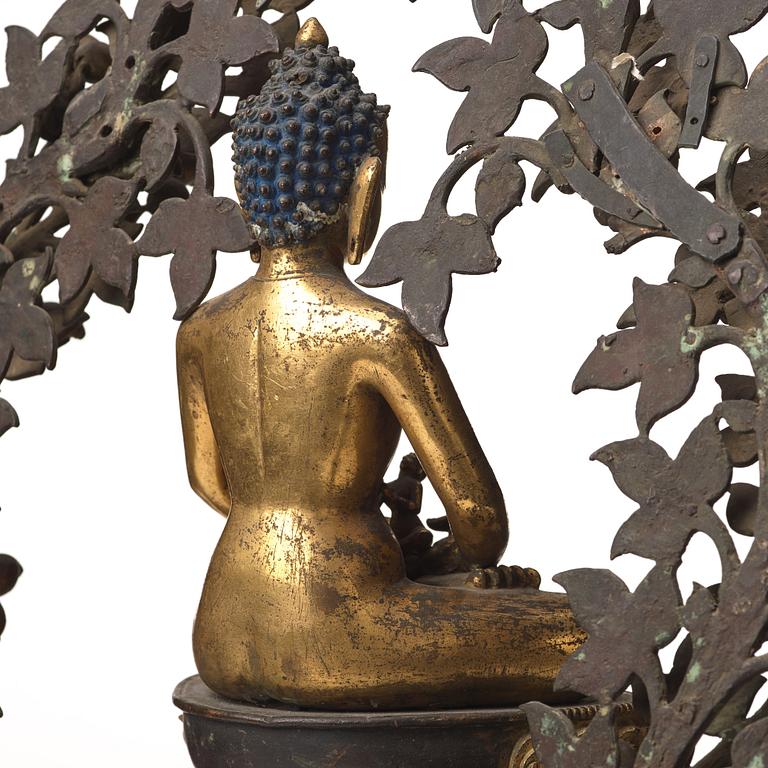 A large Nepalese gilt bronze buddha on a throne with mandorla, 18/19th Century.