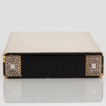 A Cartier Art Deco Vanity Case in 18K gold with enamel and baguette- and rose-cut diamonds. On the inside a mirror, two separate compartments with lid...