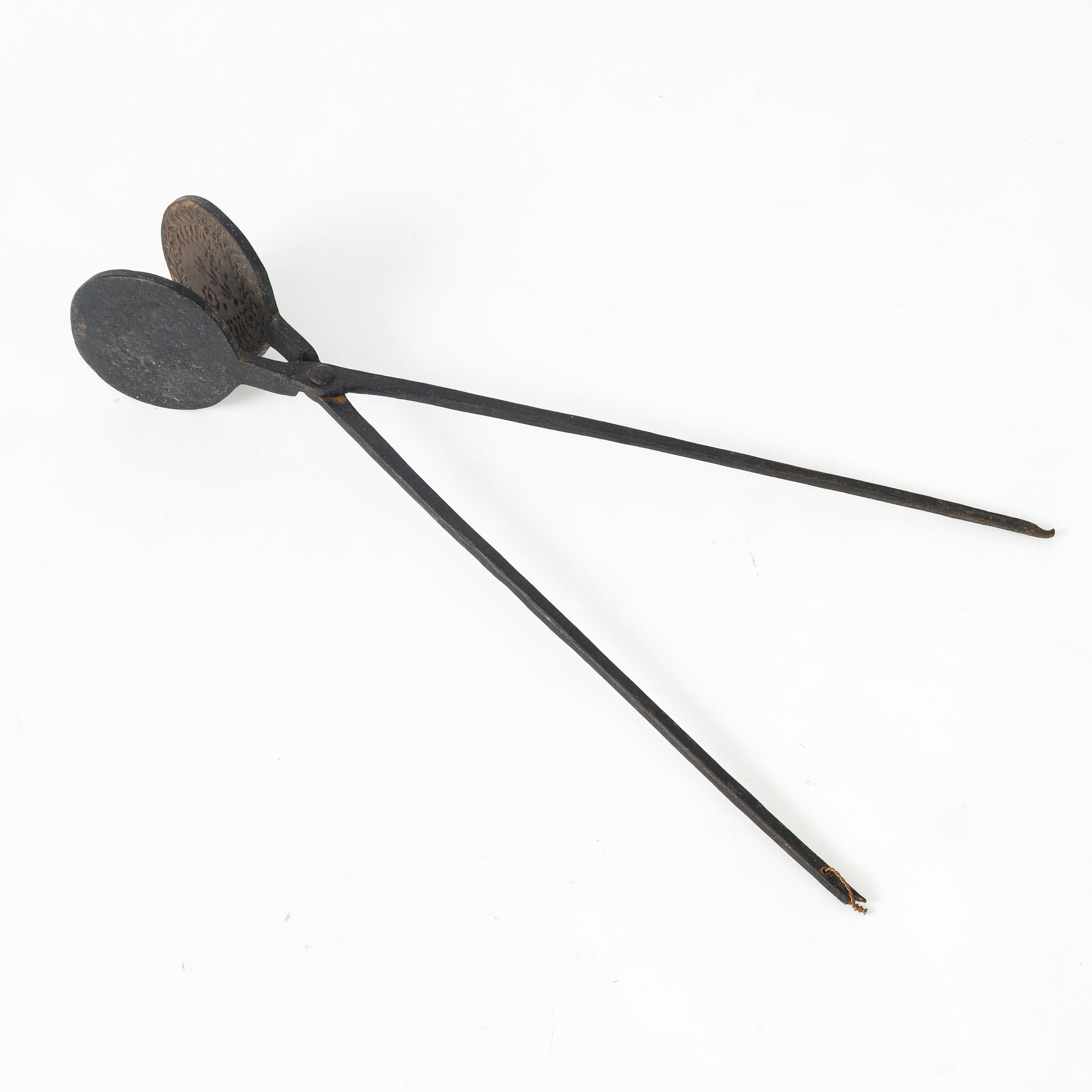 An iron wafer maker, dated 1662.