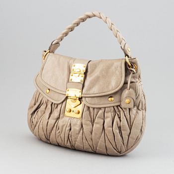Miu Miu, a light leather handbag.
