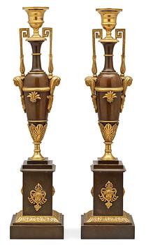 673. A pair of Empire early 19th century candlesticks.