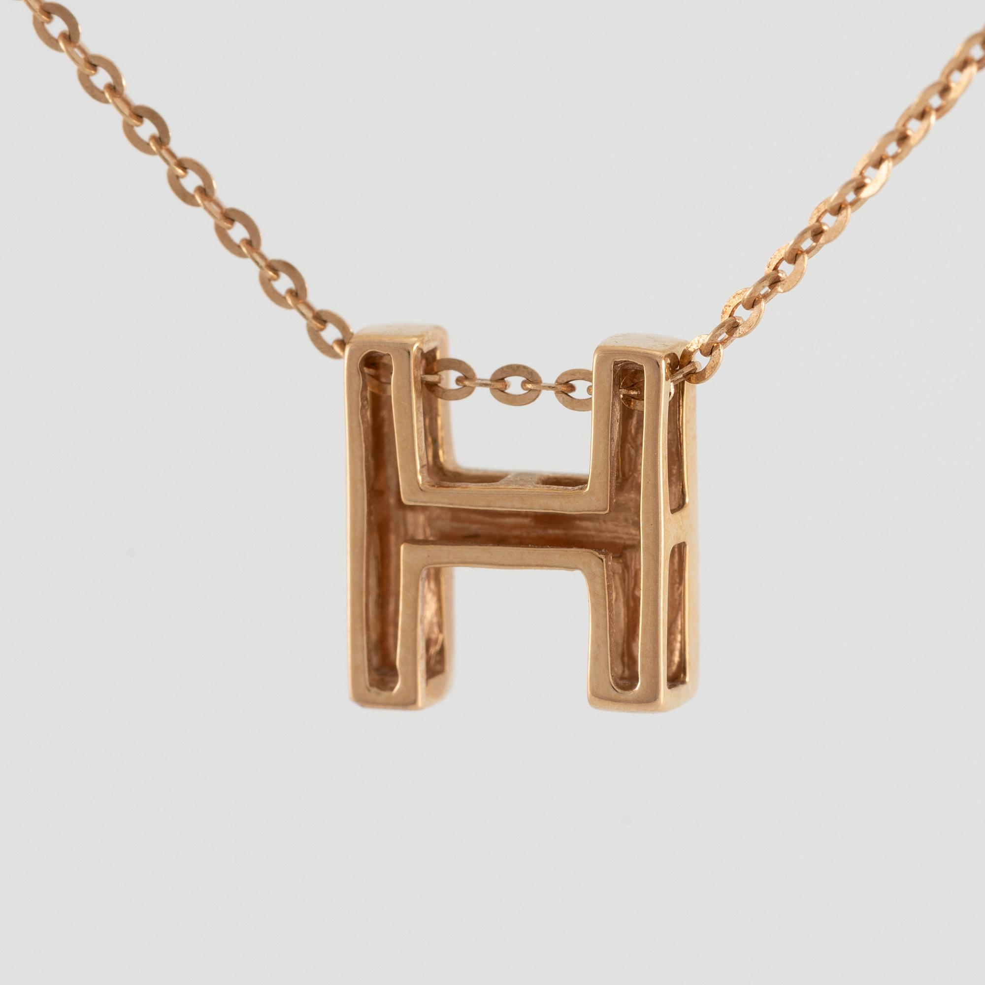 Collier, 18K guld med en berlock av bokstaven H.