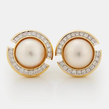 957. A pair of 18K gold and mabe pearl earrings set with round brilliant-cut diamonds.