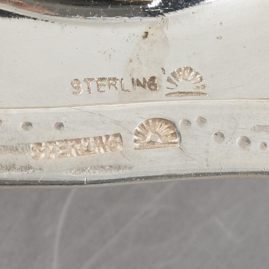 Two sterling silver tea strainers with stands, 20th century.