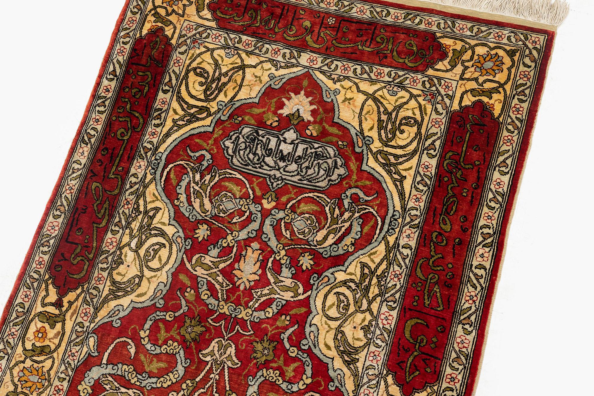 A silk and metal Hereke rug, c. 86 x 52 cm.