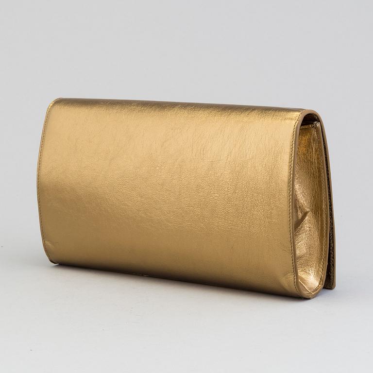 YVES SAINT LAURENT, a gold leather clutch.