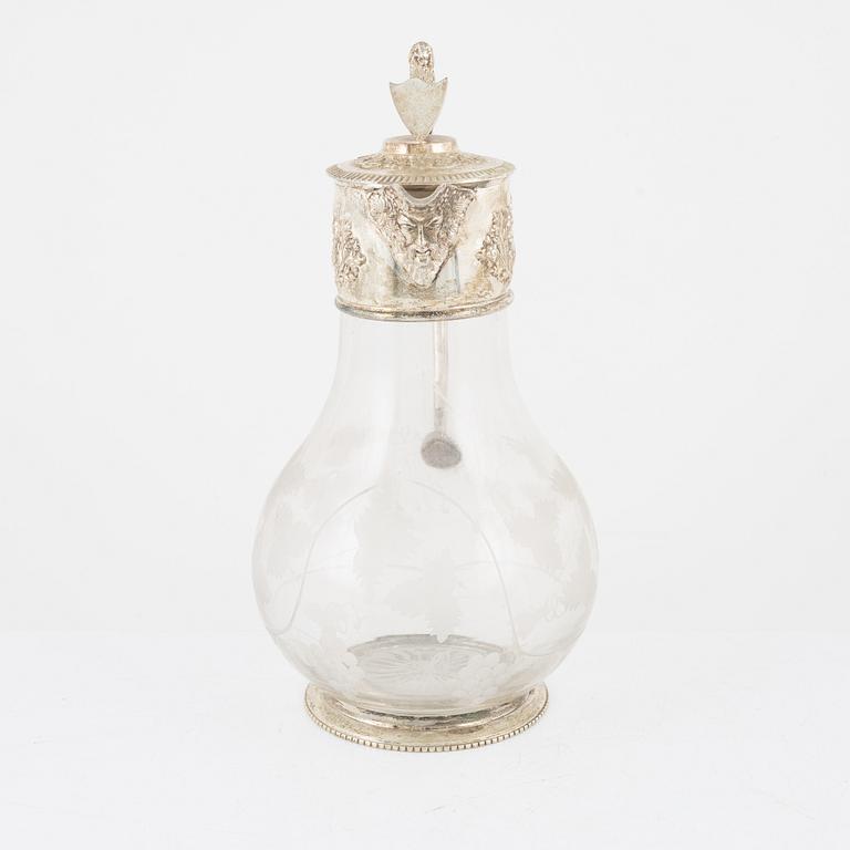 A glass and silver plated jug, around the year 1900.