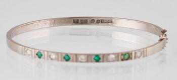 ARMRING, 18k vitguld med 5 briljantslipade diamanter och 4 smaragder, Sten Gramen, Göteborg, 1965. Vikt 13,3 gram.