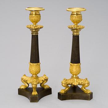 A pair of bronze late empire candlesticks from France of the first half of the 19th century.