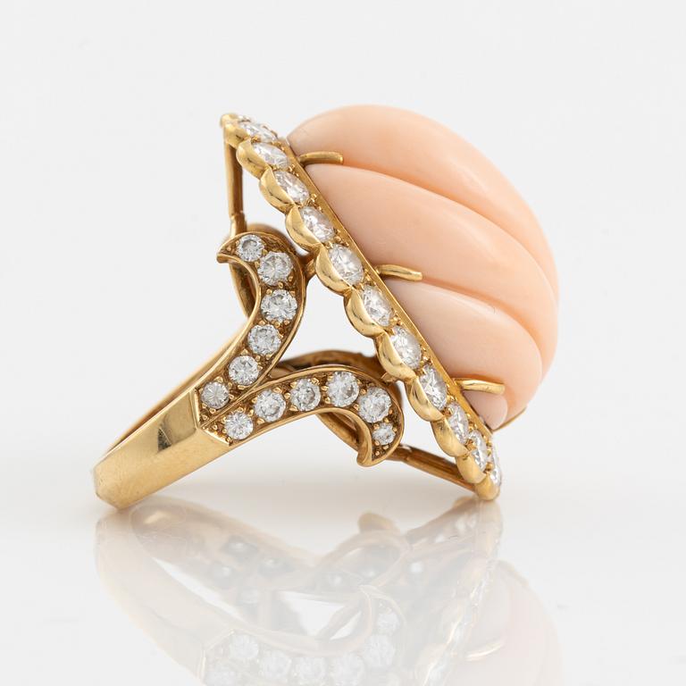 An 18K gold and coral Cartier ring set with round brilliant-cut diamonds.