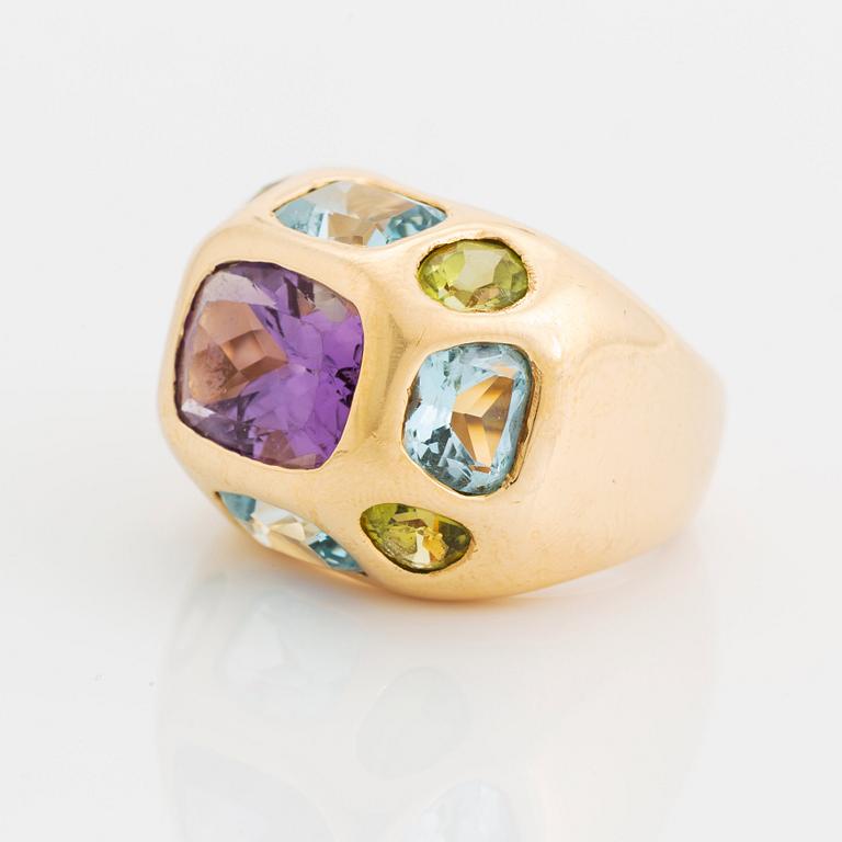 An 18K gold ring set with faceted amethyst, peridot and aquamarine.