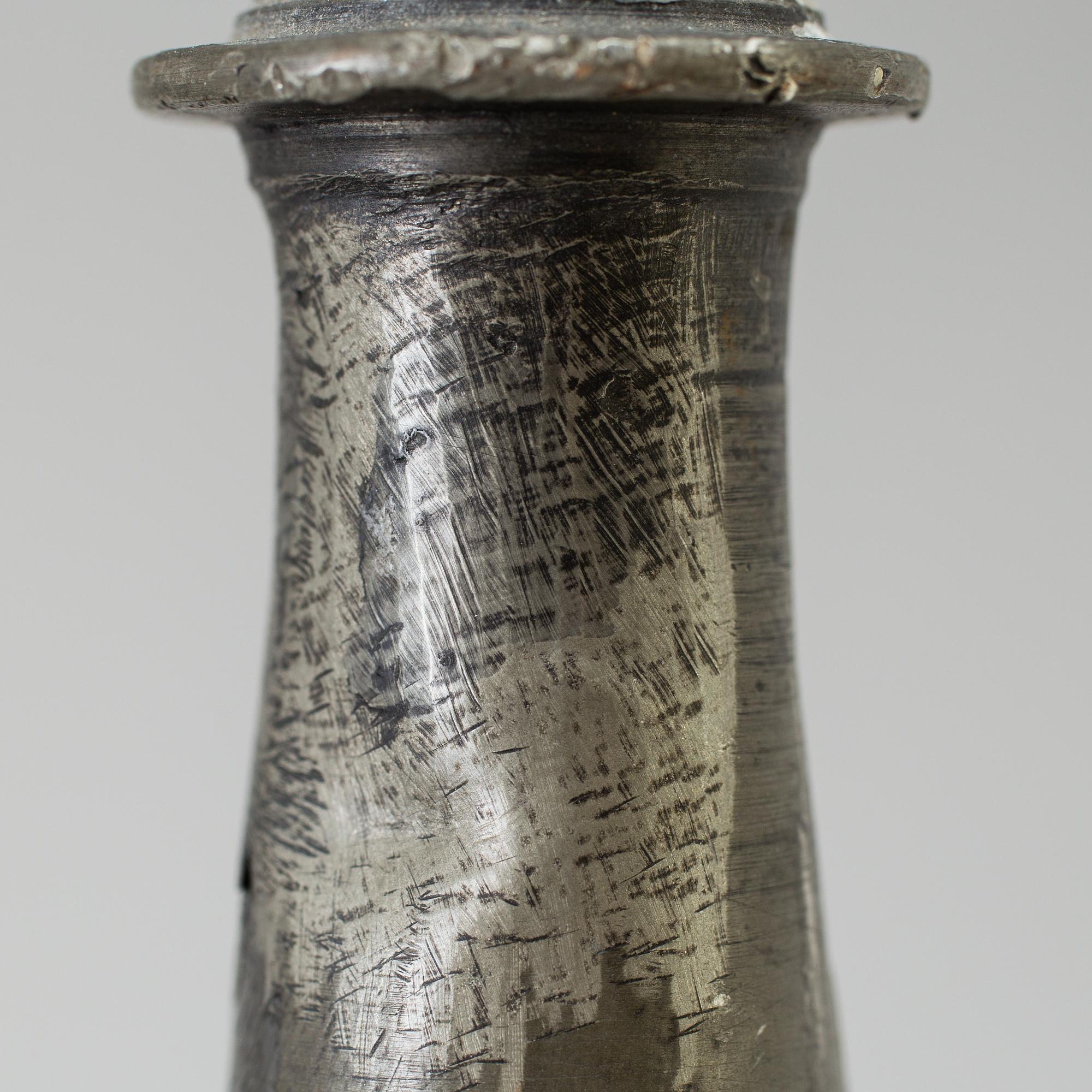 A pair of baroque pewter candlesticks, engraved date 1699.