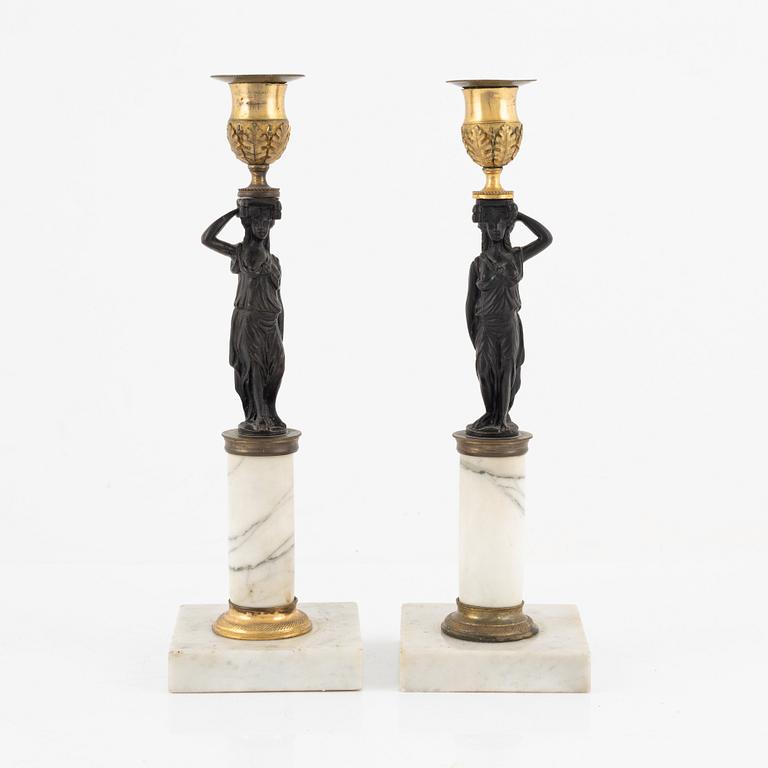 A pair of Gustavian-style ormolu, patinated bronze and marble candelsticks, circa 1900 incorporating older elements.