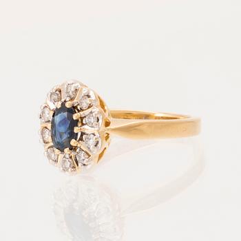 An 18K gold ring set with an oval faceted sapphire and round brilliant-cut diamonds.