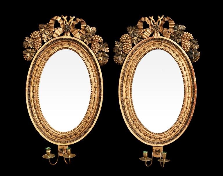 A pair of Swedish Empire early 19th century two-light girandole mirrors.